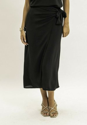 Jupe midi noire avec un nœud à la taille. Fabriquée en tissu léger, elle présente une texture lisse et une silhouette fluide.