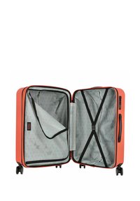 Valigia arancione con un esterno rigido, interno con motivo geometrico grigio, dotata di una tasca con zip, cinghie e quattro ruote per la mobilità.