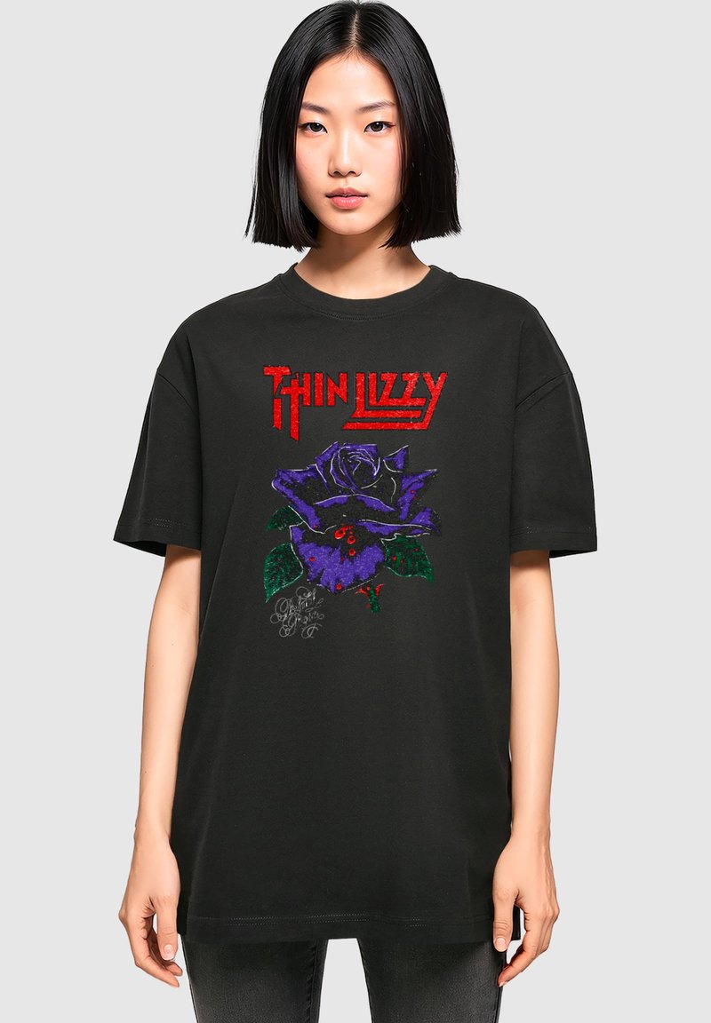 Čierne bavlnené tričko s grafickým dizajnom fialovej ruže so zelenými listami a červeným nápisom "Thin Lizzy" na prednej strane.