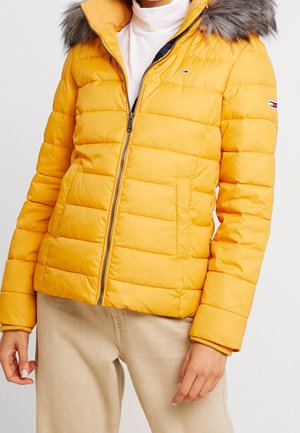 Gelbe Stepp-Wattierte Jacke mit Reißverschluss, ausgestattet mit einem pelzgefütterten Kapuzen und einem horizontal gesteppten Design. Verfügt über Seitentaschen und ein kontrastierendes Innenfutter.