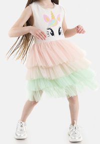 Ärmelloses Kleid mit einem Einhorn-Motiv, das einen gestuften Tüllrock in pastellfarbenen Tönen präsentiert: Rosa oben, gefolgt von Creme und Mintgrün.