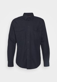 Camisa de botón de manga larga en color navy con un cuello estructurado, dos bolsillos en el pecho y puños abotonados; fabricada en una tela suave y duradera.