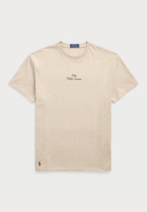 T-shirt de algodão beige com mangas curtas, decote redondo, apresentando o logótipo bordado "Polo Ralph Lauren" em castanho e um pequeno emblema do logótipo na bainha.