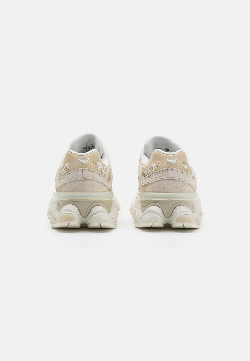 Zapatillas con una paleta de colores crema y beige, que cuentan con una parte superior de ante texturizado, un puño acolchado y un diseño de suela con patrón de olas.