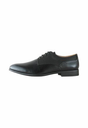 Schwarzer Herrenschuh mit Schnürverschluss, glatter Zehenpartie, strukturierten Seitenpaneelen und niedrigem gestapeltem Absatz, seitlich auf weißem Hintergrund gezeigt.