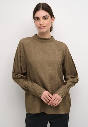 Brown textured blouse with a high neckline and long sleeves. Features button accents at the cuffs and a relaxed fit.