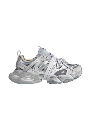 Scarpa da ginnastica grigia e bianca con suola spessa, sovrapposizioni in mesh e sintetico, e lacci lunghi liberamente annodati e drappeggiati sulla scarpa.