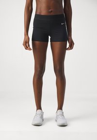 Pantalones cortos deportivos negros con una cinturilla ancha y un pequeño logotipo de Nike. La tela es suave y el diseño es ajustado al cuerpo.
