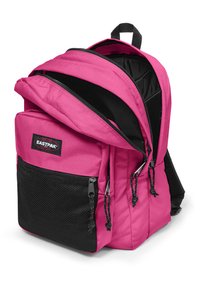 Mochila Eastpak de color rosa con un bolsillo de malla negra, compartimentos con cremallera doble, correas ajustables y un asa superior para facilitar el transporte.