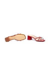 Sandales à talons en cuir verni rouge avec un bout carré, des brides ouvertes et un talon carré. La semelle est beige avec un design minimaliste.