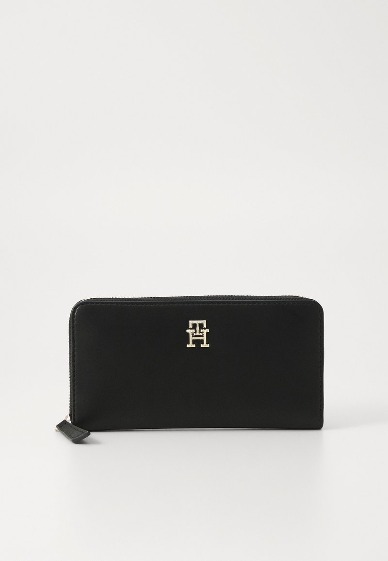 Black leather wallet with a smooth texture and a gold-tone logo on the front. Features a zip closure and a side pull tab.
