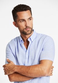 Lichtblauwe, korte mouw, knoopsluiting overhemden van linnen met een relaxte pasvorm, voorzien van een kraag en witte knopen. Lichtgewicht textuur.