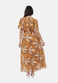Vestido maxi de tela transparente con un patrón floral en tonos cálidos. Cuenta con una cintura entallada, mangas cortas y un detalle de lazo en la espalda.
