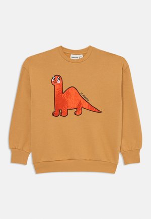 Sweat-shirt jaune moutarde avec un graphique de dinosaure rouge cartoon sur le devant, avec des contours noirs et une expression faciale ludique.