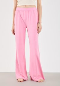 Rózsaszín bő szárú nadrág puha anyagból, rugalmas derékrésszel. A dizájn áramló sziluettet és sima textúrát kínál.