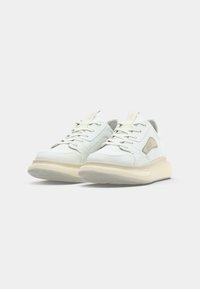 Weiße Leder-Sneaker mit strukturiertem Obermaterial, Schnürdesign und einer voluminösen, cremefarbenen Sohle. Mit Logo-Detail an der Seite.