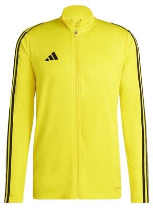 Giacca gialla con zip realizzata in tessuto liscio, con righe nere lungo le maniche e il logo adidas sul petto.