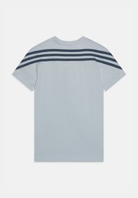 Jasnoniebieska koszula z krótkim rękawem z trzema ciemnoniebieskimi poziomymi paskami na górnej części pleców i rękawach, wyeksponowana na płasko na białym tle.