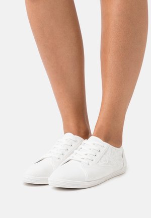 Sneakers bianchi in tela con dettagli in pizzo, punta rotonda e design con sei occhielli per allacciare. La suola ha una finitura testurizzata per una presa migliore.