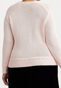 Pletený svetr v světle růžové barvě s texturovaným povrchem, který má ribovaný lem a háčkované detaily na ramenou a výstřihu.