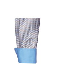 Polsino di camicia blu con un tessuto a motivo geometrico in blu navy e arancione. Il polsino presenta un bordo liscio blu a contrasto all'apertura.