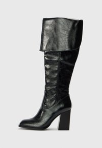 Black knee-high leather boot with folded cuff, pointed toe, and block high heel, shown in side profile on a plain background.