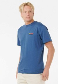Blaues T-Shirt mit kurzen Ärmeln aus Baumwolle, mit einem roten und gelben "RIP CURL"-Logo auf der linken Brust und einem Rundhalsausschnitt.