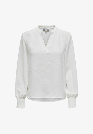 Balts garām piedurknēm blūze ar V-veida kakla izgriezumu, teksturēta auduma, elastīgas smockētas piedurknes un brīva piegrieza. Zīmola etiķete redzama iekšpusē.