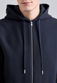Granatowy hoodie zapinany na zamek błyskawiczny z kapturem ze sznurkiem, z metalowym zamkiem i gładką teksturą materiału, idealny na co dzień.