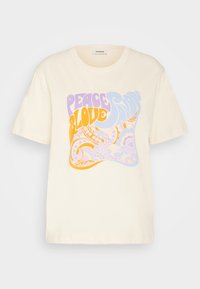 Camiseta de manga corta crema con estampado retro de paisley colorido y las palabras "Paz y Amor Sandro" en púrpura, naranja y azul en el frente.