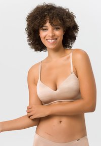 Hellbeige BH mit glatter Textur, V-förmigem Ausschnitt und dünnen, verstellbaren Trägern. Verfügt über ein nahtloses Design für ein sauberes Finish.