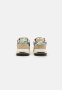 Sneaker aus einer Mischung aus braunem Wildleder und grauem Stoff, mit einem mintgrünen Akzent an der Ferse und einer gepolsterten beigen Sohle.
