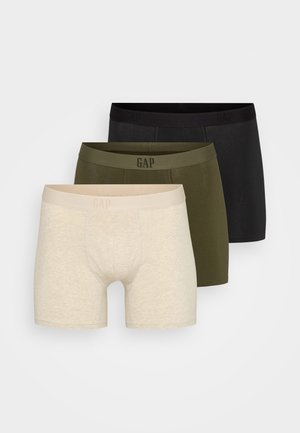 Tre par herrboxershorts i beige, olivgrön och svart. Varje par har ett mjukt tyg, en figurnära passform och en elastisk midja med "GAP"-logotyp.