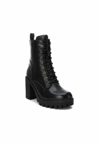 Botas de cuero negras hasta el tobillo con punta redonda, cierre de cordones en la parte delantera y tacón cuadrado grueso. Superficie texturizada y suela de goma con agarre.