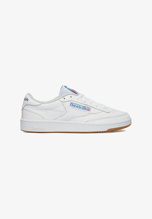 White low-top Reebok sneaker with blue brand logo, white laces, and gum sole, shown from the side on a white background.