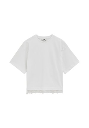 Chemise blanche à manches courtes avec col rond et bordure en dentelle festonnée à l'ourlet, présentée sur un fond blanc.