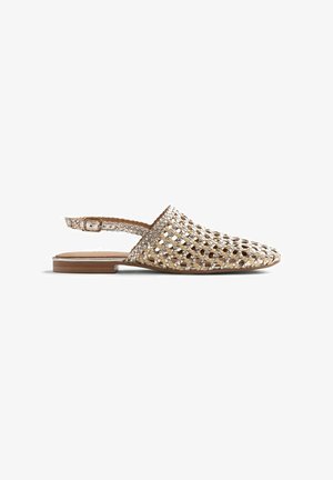 Scarpa slingback piatta intrecciata in oro metallizzato con punta appuntita e cinturino regolabile con fibbia, suola liscia e tacco basso.