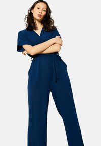 Navy blue wikkeloverall met korte mouwen, een cinched taille en wijde broekspijpen, gemaakt van gladde stof en voorzien van een zelfbindende riem.