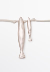 To lange sølvmetallic fiskelignende genstande hængende fra en knyttet beige snor mod en hvid baggrund.