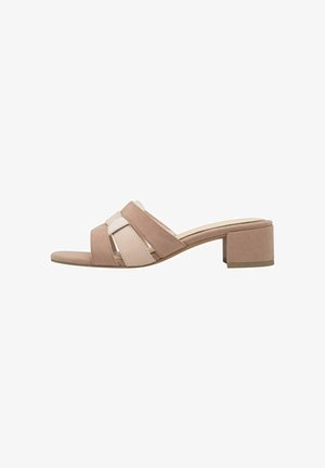 Sandale à talon bloc avec un design à bride croisée en suède léger rose pâle et beige. Bout ouvert et semelle plate pour le confort.