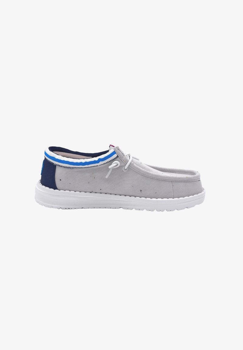 Lysegrå afslappet slip-on sko med hvid sål, navy hæl, blå og hvide kanter samt hvide snørebånd, vist fra siden på hvid baggrund.