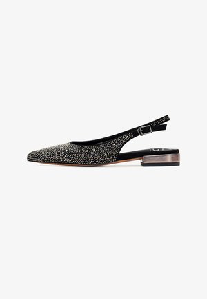 Chaussures noires à talon slingback avec un bout pointu, ornées de clous métalliques, présentant un petit talon carré et un tissu texturé. Sangle réglable.