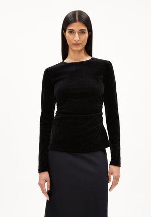 Zwarte fluwelen top met lange mouwen en een ronde hals, met een fitted silhouet en subtiele draperingdetails bij de taille.