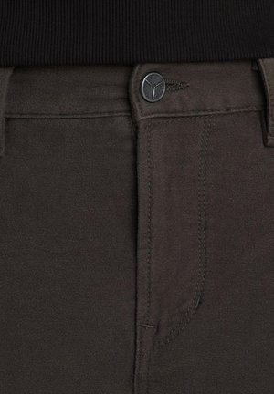 Pantaloni grigi scuri realizzati in tessuto morbido, dotati di chiusura con bottone metallico, cuciture a vista e tasche laterali. La vita è elastica e rigata.