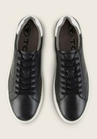 Schwarze Ledersneaker mit weißen Gummisohlen, ausgestattet mit schwarzen Schnürsenkeln und einer grauen Mesh-Fütterung. Einfaches Design mit minimalen Akzenten.