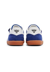 Blå mockaskor med vita accenter och en klassisk gummisula. Svart logotyp på hälen med en bi-design. Dubbel remknäppning.