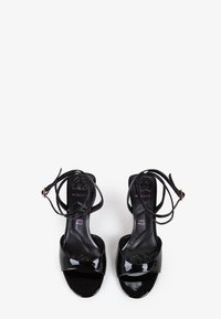 Sandali con tacco alto in vernice nera, caratterizzati da una larga fascia frontale, delicate cinghie alla caviglia e un elegante design open-toe.