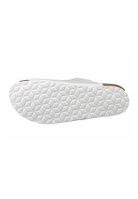 White slip-on shoe with a flexible rubber sole featuring a hexagonal tread pattern and a contrasting brown accent at the heel.