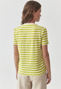 Kortærmet t-shirt med vandrette grønne og hvide striber, rund halsudskæring og blødt bomullsmateriale. Casual fit, synlig syning ved kanten.