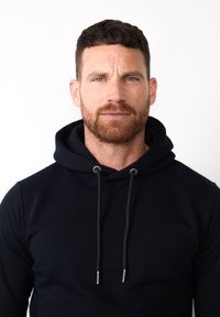 Sudadera marina hecha de una tela suave, con capucha ajustable y herrajes plateados en los extremos. Diseño ceñido con una textura lisa.